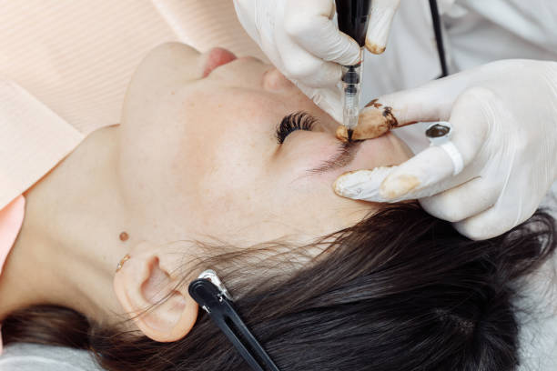 istock Permanent makeup, tattooing of eyebrows. Cosmetologist applying make up 1191681956