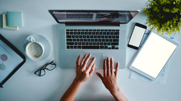 Kicking productivity into high gear High angle shot of an unrecognizable businesswoman working on digital devices in an office touchpad stock pictures, royalty-free photos & images