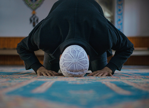 Toma de primer plano de un joven musulmán adorando en una mezquita photo