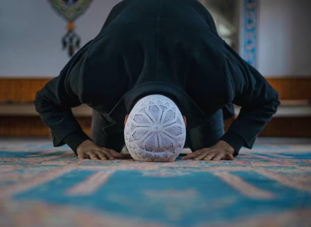 tiro do close-up de um homem novo muçulmano que adora em uma mesquita - muslim culture - fotografias e filmes do acervo