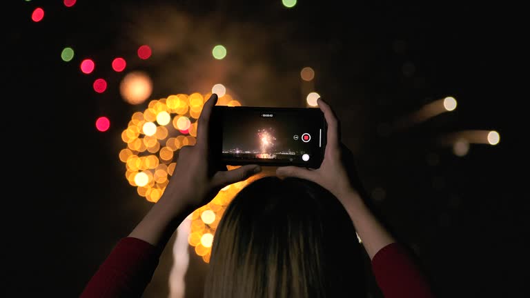 4K Slow motion New year festival Asian women She is using a mobile phone to photograph fireworks during the end of the year celebration.