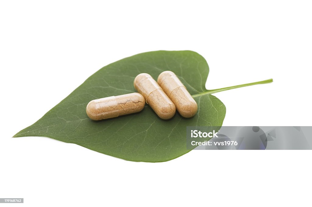 Pilules sur Feuille verte solated sur blanc - Photo de Aliment libre de droits