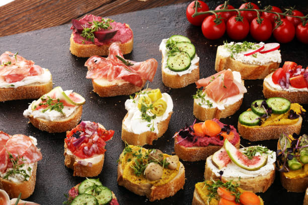 verschiedene bruschetta mit verschiedenen toppings. appetitliche bruschetta oder brie crostini. vielzahl von kleinen sandwiches. mix bruschetta auf dem tisch - bread cheese bruschetta canape stock-fotos und bilder