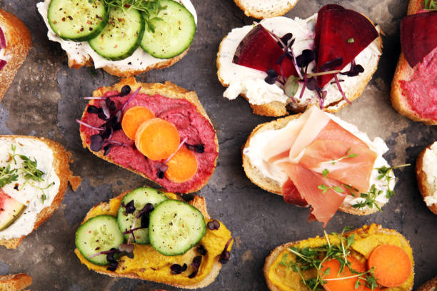 istock Assorted bruschetta with various toppings. Appetizing bruschetta or brie crostini. Variety of small sandwiches. Mix bruschetta on table 1191689425