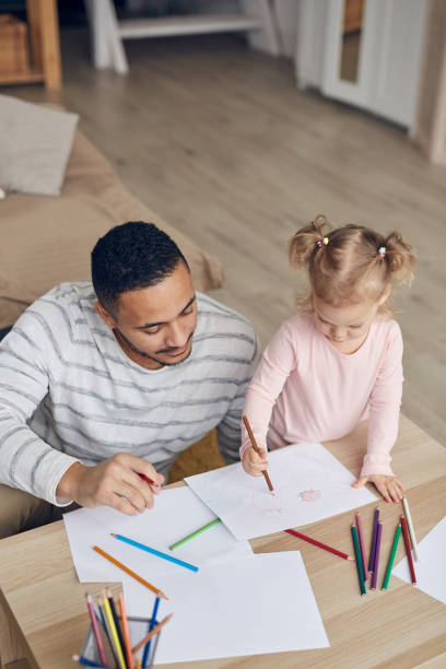 istock Cute Little Girl Drawing with Dad 1191693108