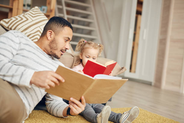 istock Little Girl Reading Books with Dad 1191693294