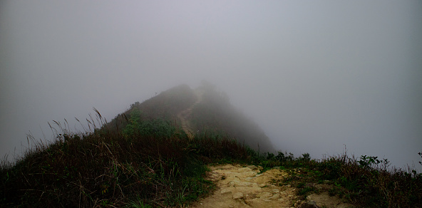 Hiking inside the fog without clearly seeing the path. Walk on until reaching the destination