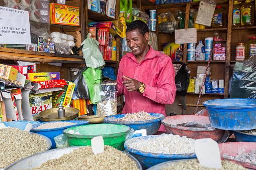 Addis Ababa, Ethiopia - May 21, 2016: Market trader selling green unroasted coffee beans at the Shola market in Addis Ababa, Ethiopia