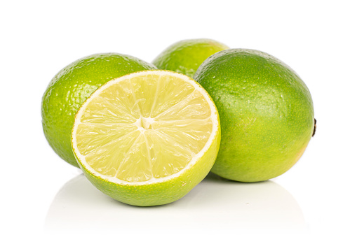 Group of three whole one half of sour green lime isolated on white background