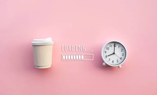 Photo of Drinking,refreshment in morning concepts with coffee cup and clock(watch) with loading text on color background