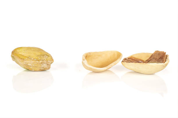 Group of one whole two pieces of salted pistachio isolated on white background