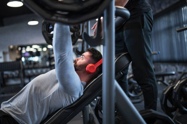 istock Two friends exercising bench press in gym 1191702140