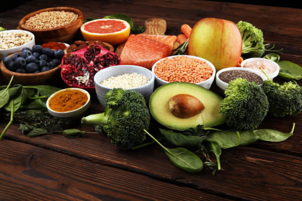 istock Healthy food clean eating selection: fish, fruit, vegetable, cereal, leaf vegetable on rustic background 1191702456
