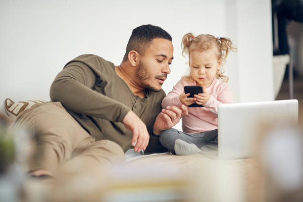 istock Father and Daughter Playing with Smartphone 1191704161