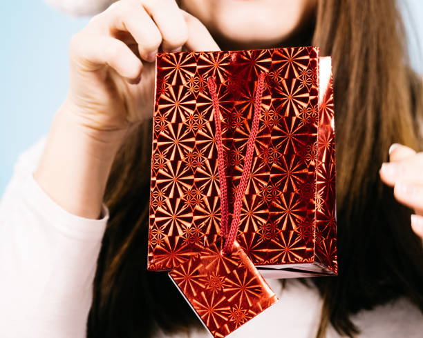 istock woman holds red gift bag in hands 1191706105