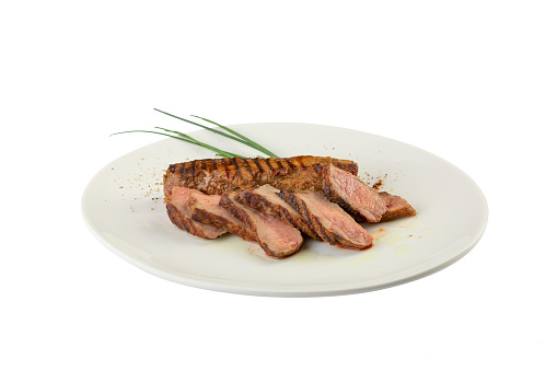 Freshly made spicy beef steak decorated with rosemary. Isolated over white background