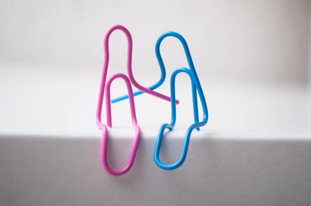 istock two paperclips sitting on white desk - love concept 1191709724
