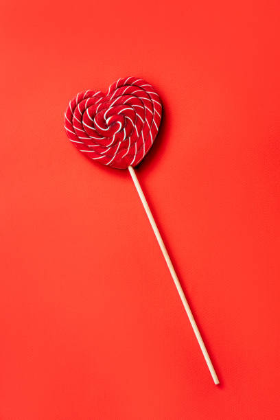 istock Heart shaped large red and white striped sugar lollipop. 1191709931