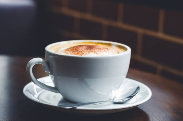 istock close up modern coffee the cappuccino on wood background with coffee bubble foam pattern and texture in white cup looking and feel so delicious on glasses table in coffee shop. 1191710099