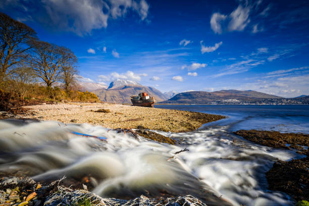 old wreck near Fort William in Scotland with the Ben Nevis in the background old wreck at Corpach near Fort William in Scotland with the Ben Nevis in the background fort william stock pictures, royalty-free photos & images