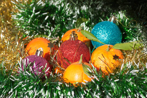 istock Orange tangerines and multi colored Christmas balls 1191718112