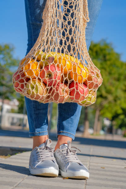 istock Front view on female legs, fruits and vegetables in an eco-friendly string 1191718315