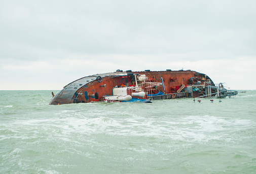A rusty, stranded and sunken shipwreck vessel.