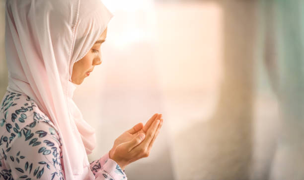 Young beautiful muslim women open palm, peaceful praying in mosque. Young beautiful muslim women open palm, peaceful praying in mosque. salah islamic prayer photos stock pictures, royalty-free photos & images