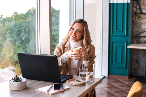 istock Beautiful business woman sitting in cafe and taking notes in notebook. 1191718779