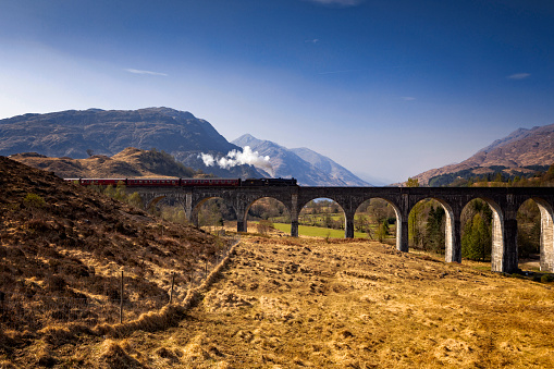 Jacobite steam train on the Glenfinnan Viaduct, famous from Harry Potter, in Scotland