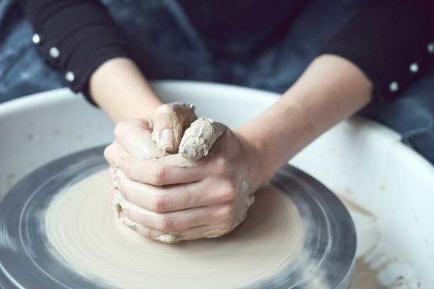 車輪に陶器を作る女性、手をクローズアップ、陶器の作成。手仕事、工芸品、肉体労働、ビジネス。余分なお金を稼ぎ、趣味を現金に変え、情熱を仕事に変える - potter small business pottery happiness ストックフォトと画像