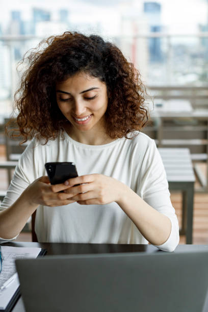 istock Smiling young woman using mobile phone 1191722950
