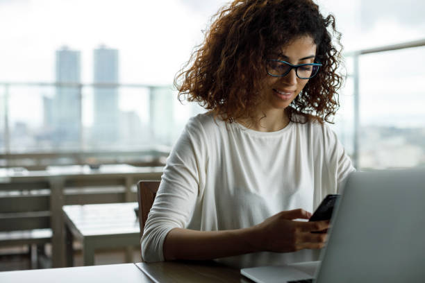 istock Smiling young woman using mobile phone 1191722955