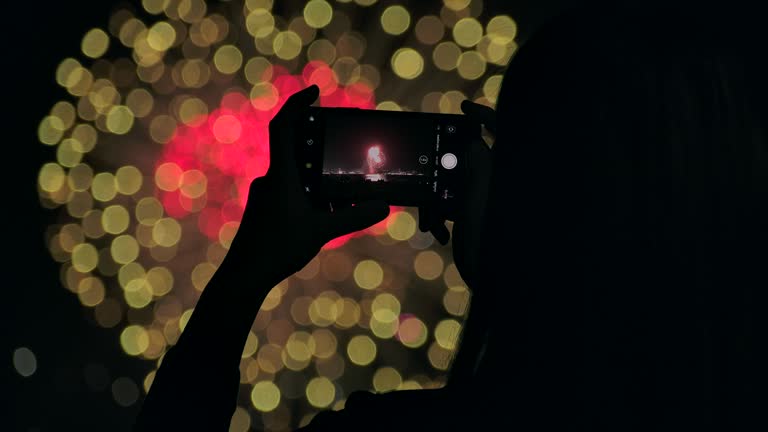 4K Slow motion New year festival Asian women She is using a mobile phone to photograph fireworks during the end of the year celebration.