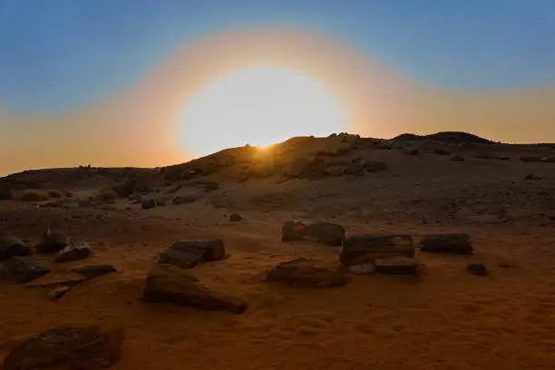 The setting of the mighty sun over the petrified woods in the desert of Sudan