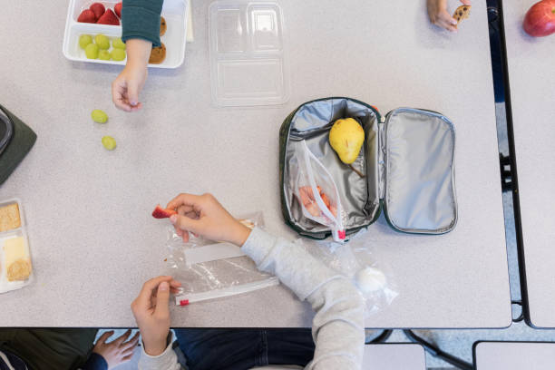 hochwinkelansicht von schulkindern beim mittagessen - lunch box child school lunch stock-fotos und bilder