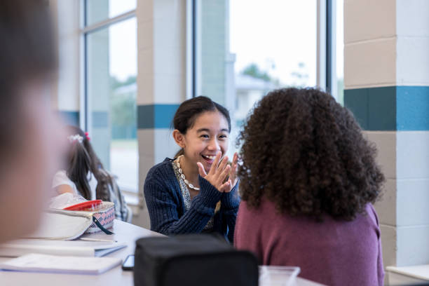 istock Schoolgirls laughing together during lunch 1191725332