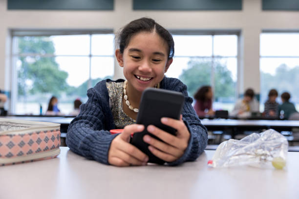 istock Smiling girl using smartphone during lunch 1191725342