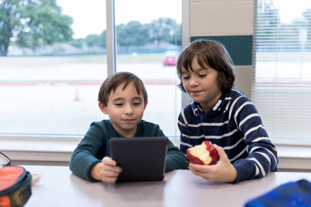 istock Boys play with tablet in elementary school cafeteria after lunch 1191725471