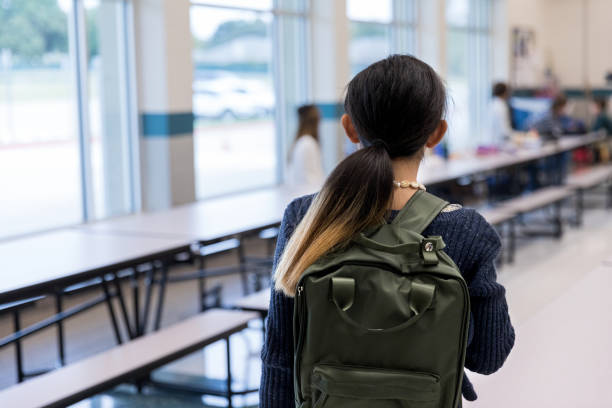 istock Unrecognizable middle school girl walks timidly into cafeteria 1191725499