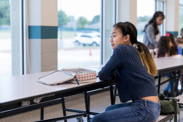 istock Middle school girl looks out window during lunch break 1191725505