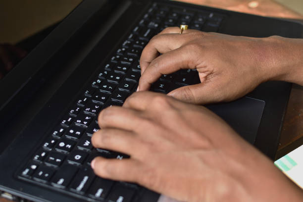 Cropped image of a young man working on his laptop .