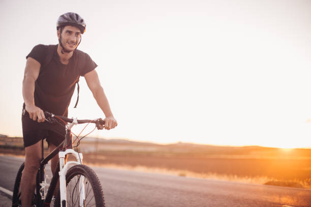 istock Cheerful young man riding a bike 1191726064