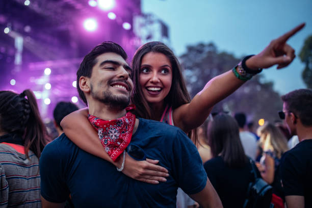 A young couple enjoying a performance at a festival together
