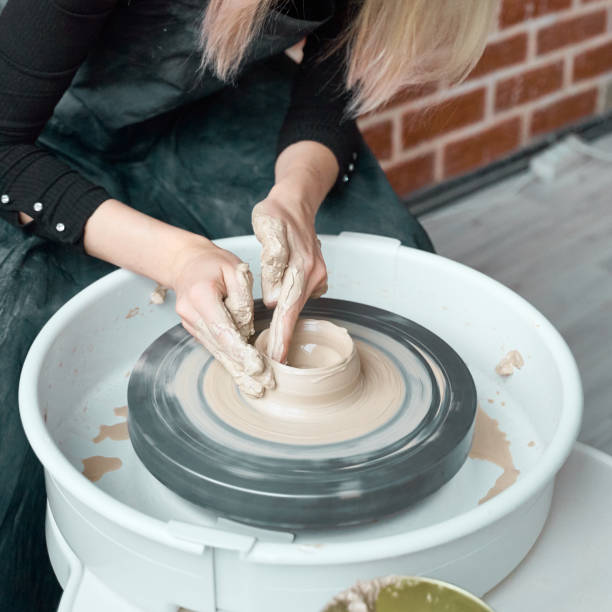 istock Woman making ceramic pottery on wheel, hands close-up, creation of ceramic ware. Handwork, craft, manual labor, business. Earn extra money, turning hobbies into cash and turning passion into job 1191728719