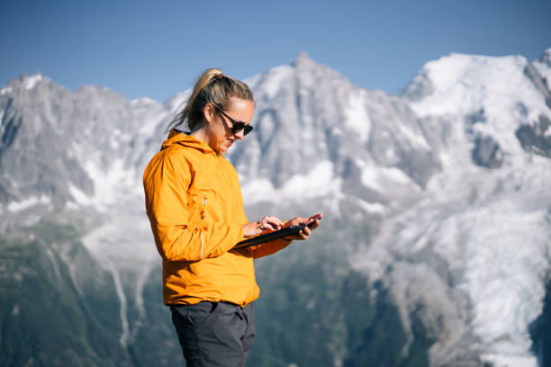 istock Female hiker relaxing on mountain ridge uses digital tablet 1191728831