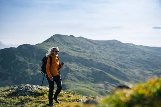 istock Female hiker relaxing on mountain ridge uses digital tablet 1191728833