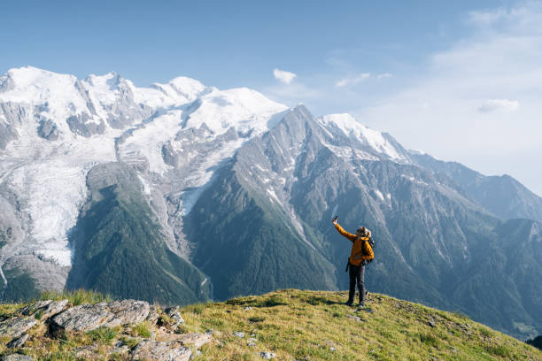 istock Female hiker relaxing on mountain ridge uses digital tablet 1191729170