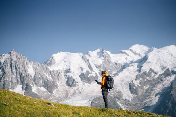 istock Female hiker relaxing on mountain ridge uses digital tablet 1191730065