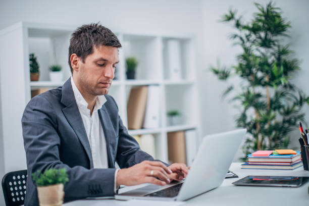 istock Serious businessman using laptop at the office 1191730236